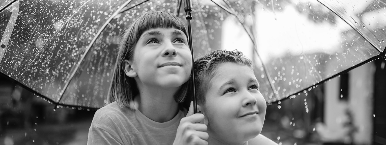 Two kids under umbrella